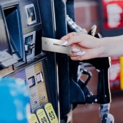 A woman uses her Discover it® Chrome card to pay for fuel at the pump.
