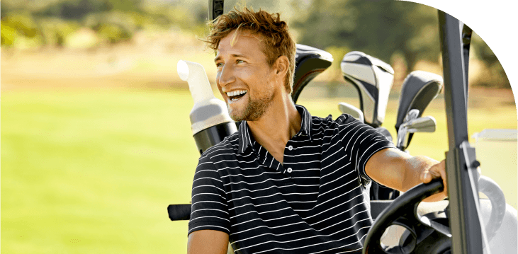 Man smiling while sitting in a golf cart.