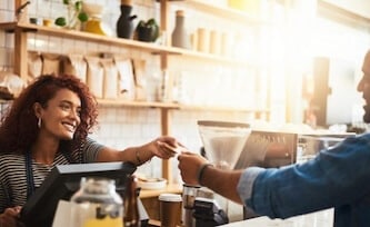 Cashier handing back debit card after purchase.