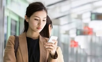 Woman using her mobile device while waiting for her flight.