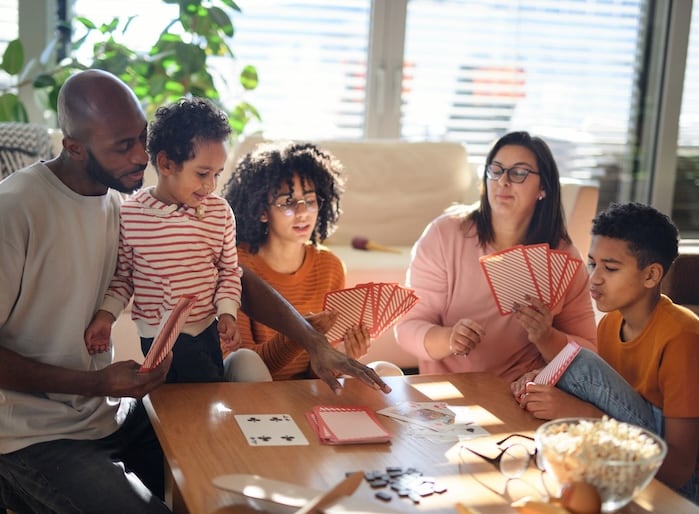 Family at home playing a card game.