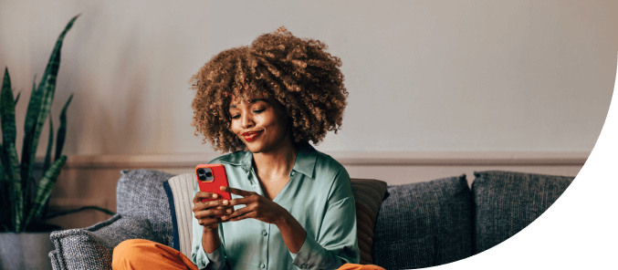 Woman sitting on couch while using her mobile device to take product quiz.