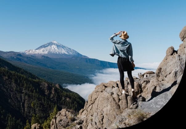 Woman hiking stops to look at the mountain view.
