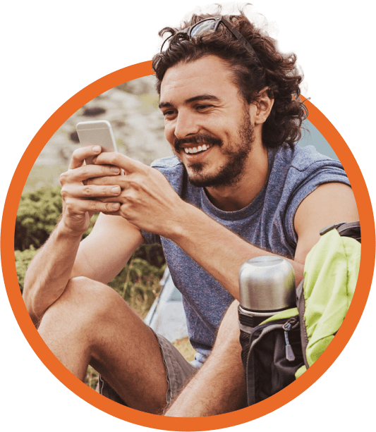 Man using his mobile device while sitting outside.