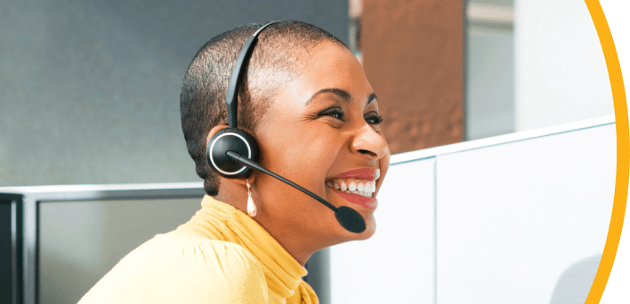 woman in yellow shirt smiling and wearing headset