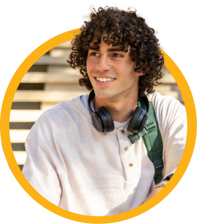 Young man with curly hair, wearing headphones and a white shirt, smiling and looking to the side