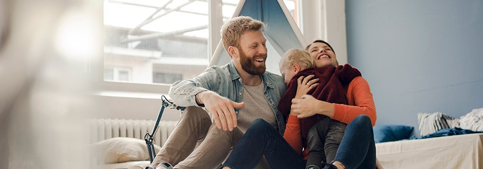 A father, mother, and son laughing together after refinancing their home with a home equity loan.