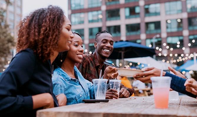 A group of people eating at an outdoor table.