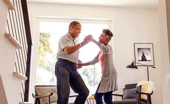 Couple dancing in a living room.
